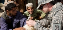 U.S. Army veterinary corps officer examines a goat in the field