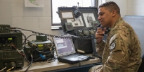 Soldier does a voice and data radio check using high frequency radio equipment.