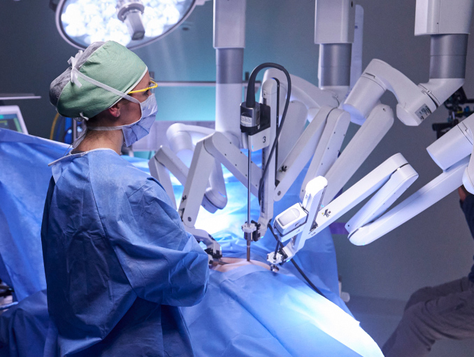A female Army surgeon using a surgical robot on a patient during a procedure