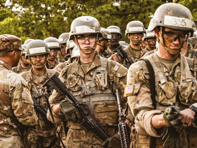 A group of male Soldiers in combat uniform, hard helmets, and safety goggles holding rifles