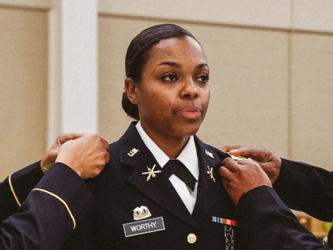 A female Officer Candidate is pinned during an Officer Candidate School graduation ceremony
