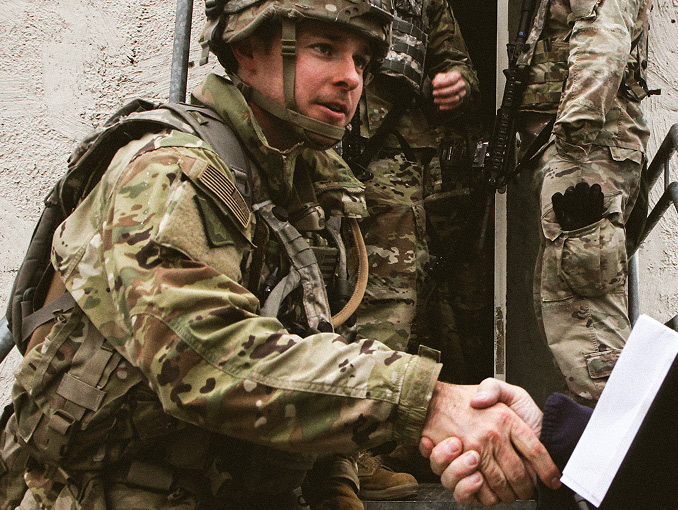 Civil Affairs Soldier in uniform shaking someone’s hand.