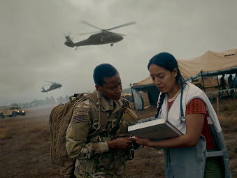 Soldier and a medical professional standing outside a field tent