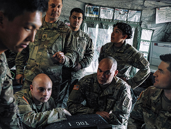 Seven male Soldiers sitting and strategizing together