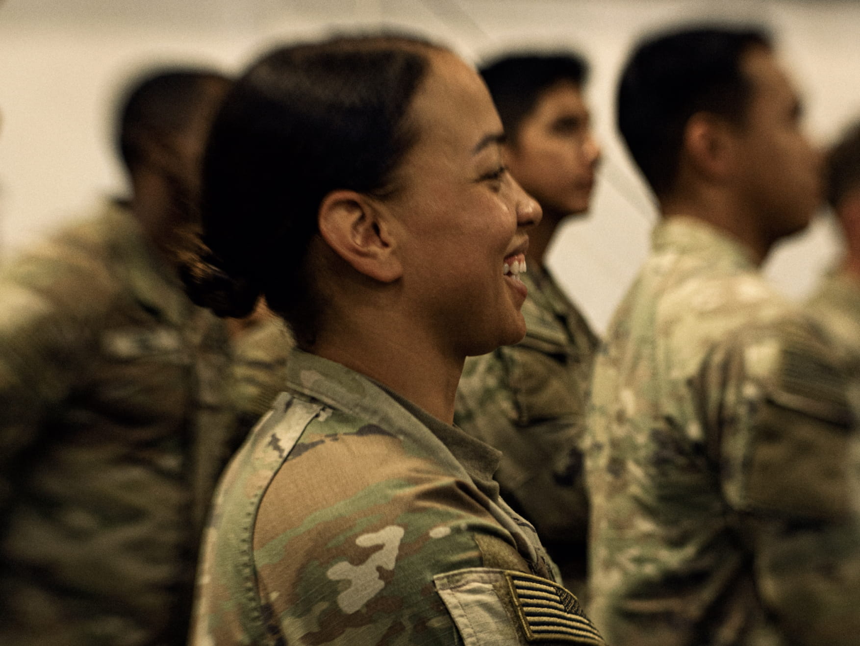 Uniformed Soldier standing in a crowd smiling