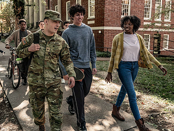 ROTC Cadet walking on a sidewalk alongside another male and female