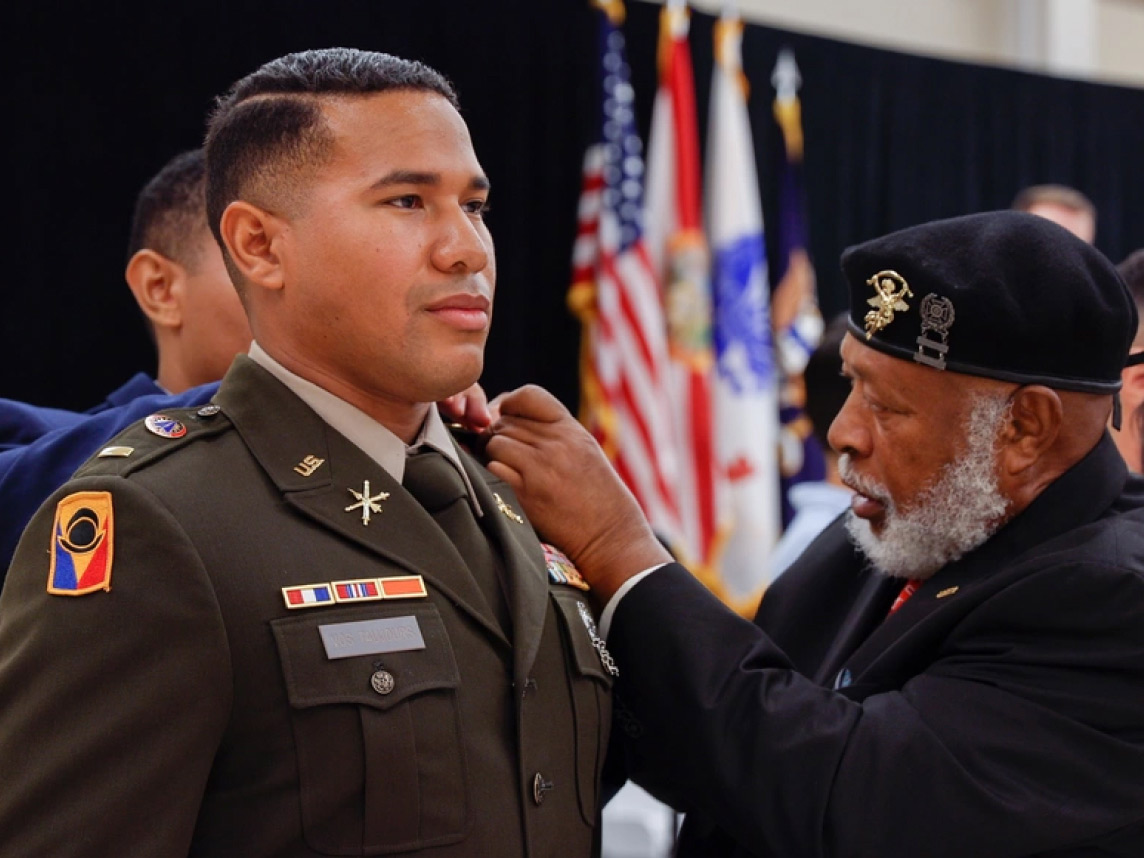 An Officer Candidate is pinned during an Officer Candidate School (OCS) graduation ceremony