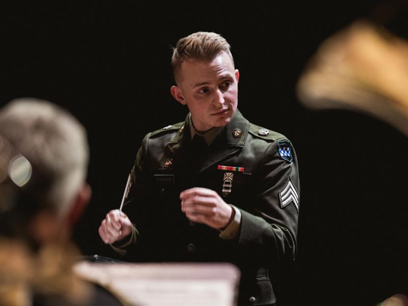 Un miembro de las Bandas del Army dirigiendo una actuación