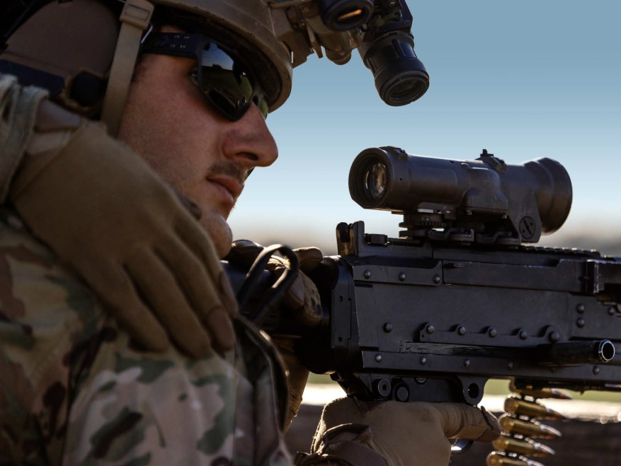 Closeup of a Soldier in uniform with goggles on staring into a sniper lens