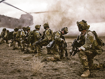 Line of Soldiers kneeling down in a field with a helicopter overhead