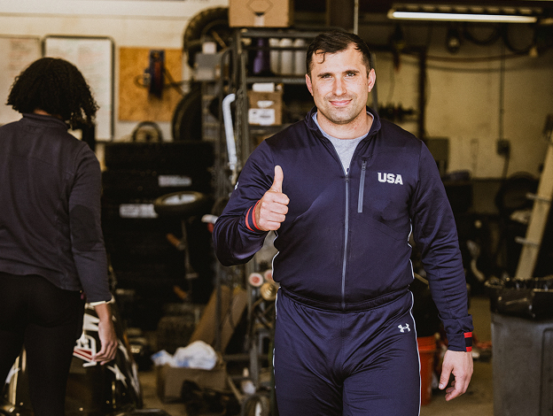 Sergeant Frank Del Duca wearing a dark blue USA uniform walking towards the camera giving a thumbs up