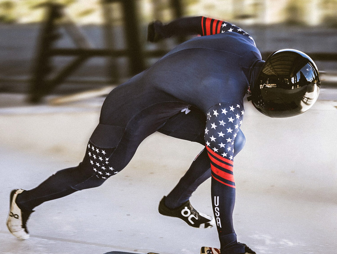 U.S. Army World Class Athlete leaned forward in uniform and running on ice with a helmet on