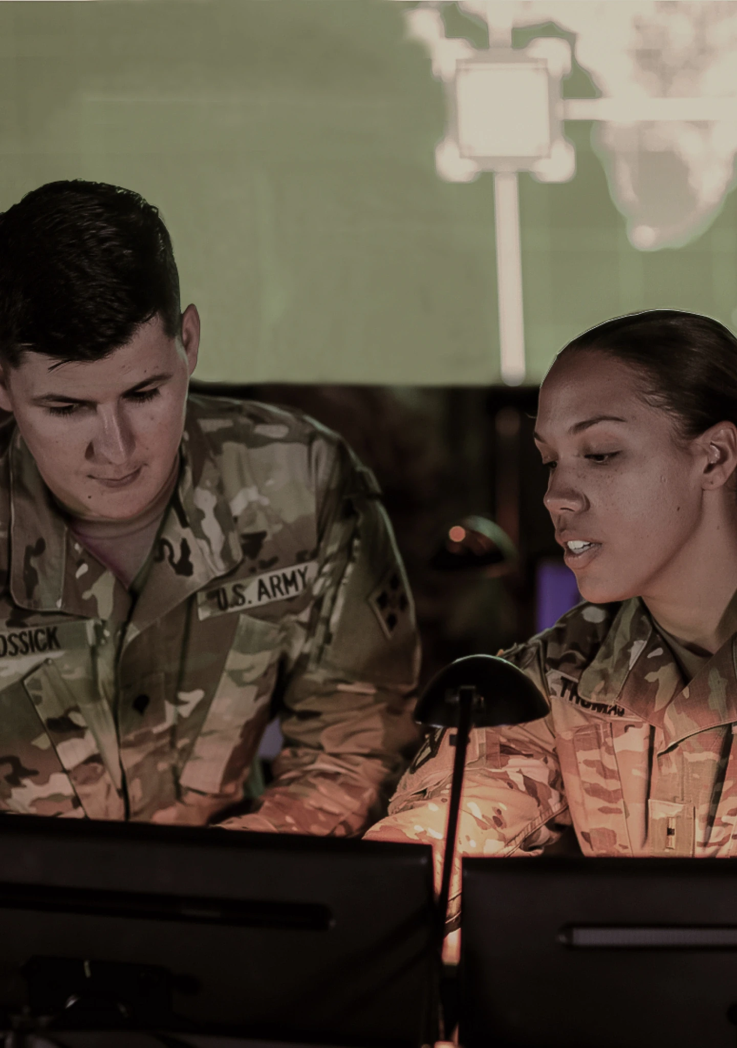 Two Soldiers in combat uniform working at a computer