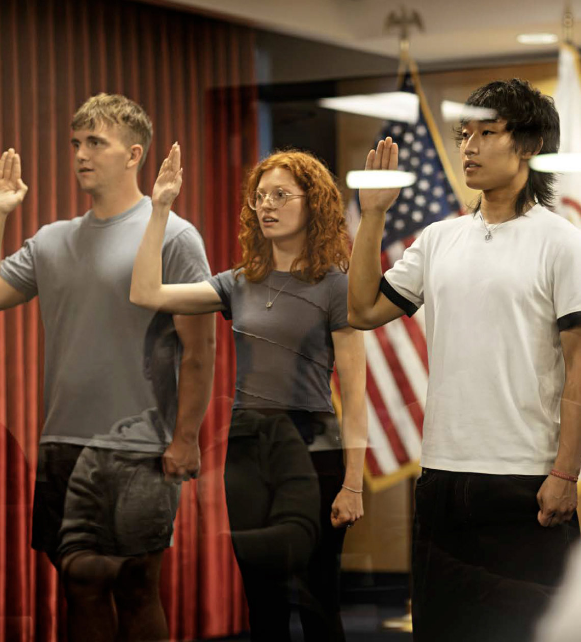 Three enlisted recruits standing side by side next to each other taking the Army oath with each holding up their right hand