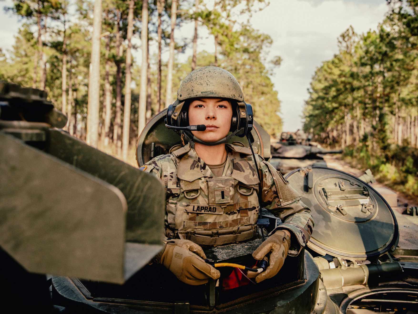 A female armor officer sitting aboard a tank