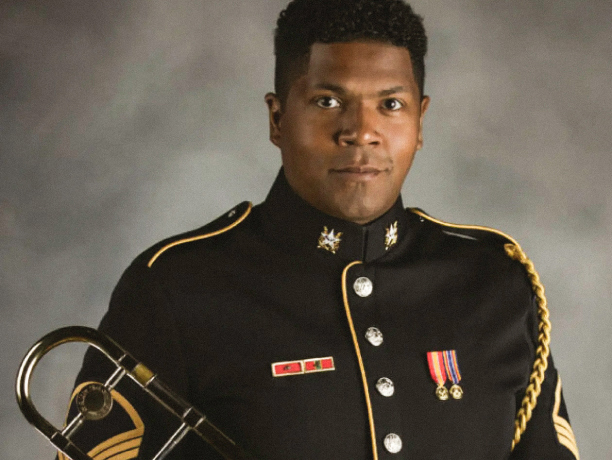 An Army Musician poses for a photo holding his trombone