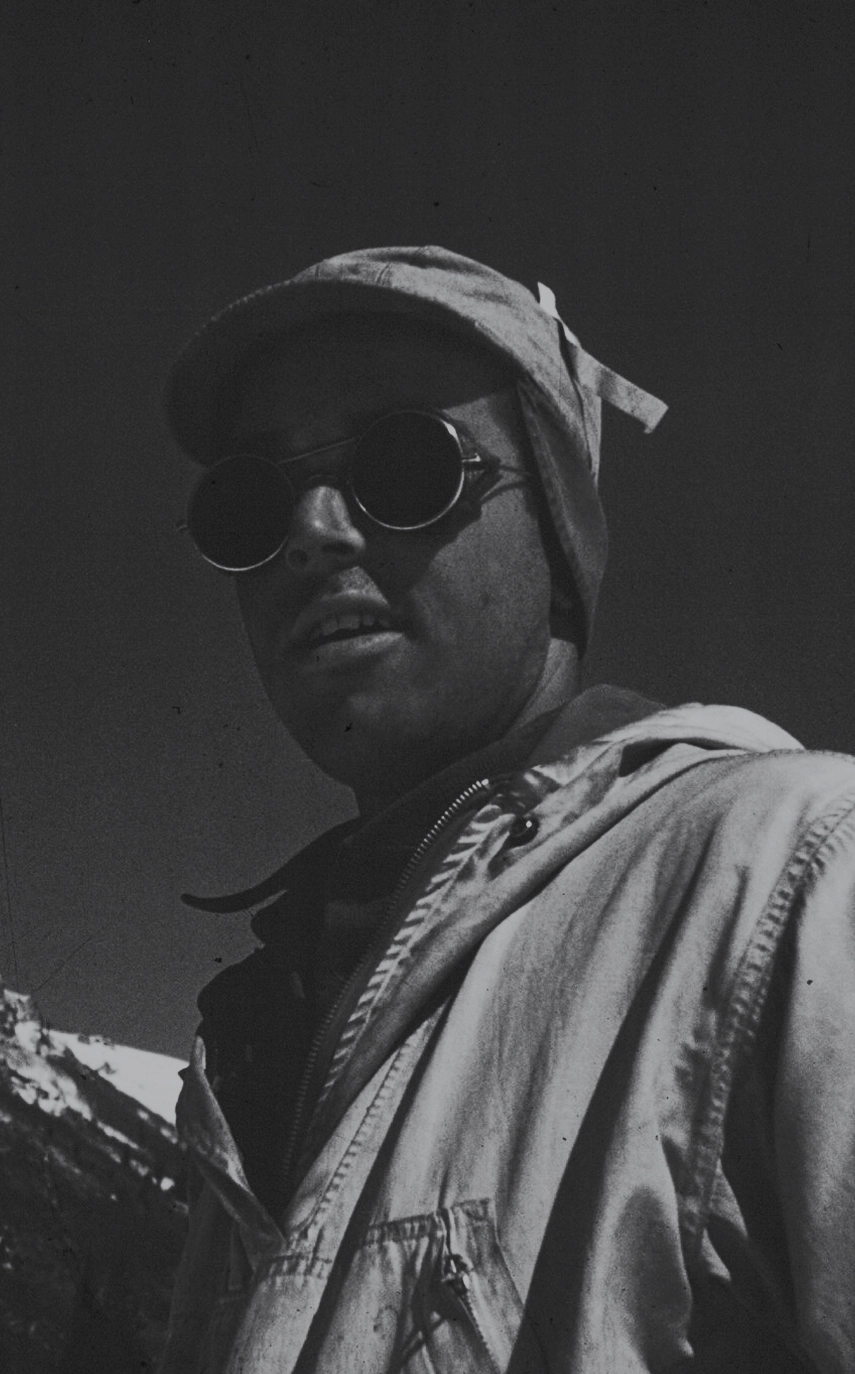 Pete Seibert usando gafas de sol y un abrigo blanco, con un cielo despejado de fondo