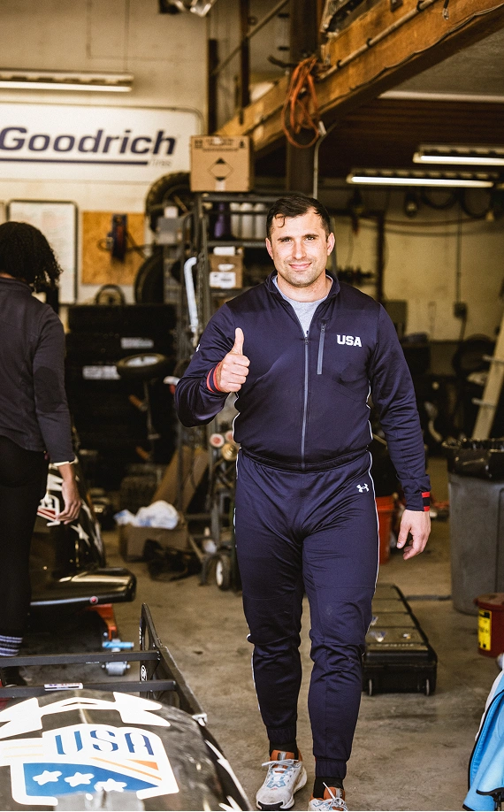 Sergeant Frank Del Duca wearing a dark blue USA uniform walking towards the camera giving a thumbs up