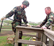 Airborne Ranger, Master Sergeant Hacker, coaches Cadet Josh Nikes through proper procedures before he rappels down the tower.