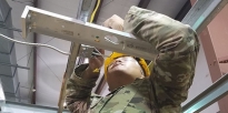 Soldier installing a light fixture.