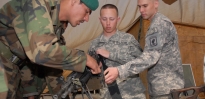 Small-arms/artillery repairmen demonstrate proper loading of a weapon