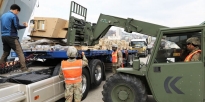 Soldier loading a trailer with turrets.
